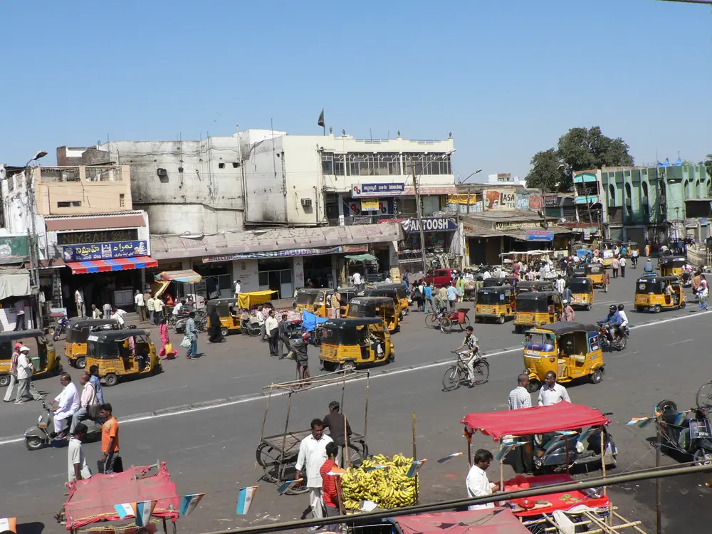 Auto-rickshaws and traffic on a busy Indian street